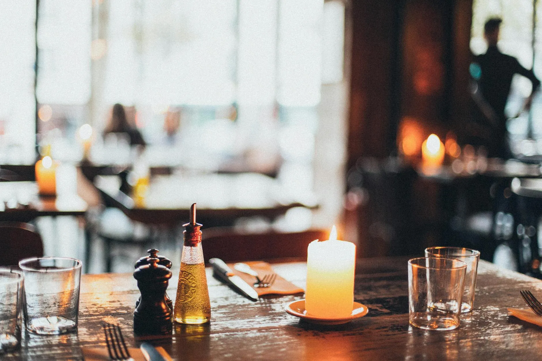 Warm verlicht restaurantinterieur met kaarslicht en gedekte tafel