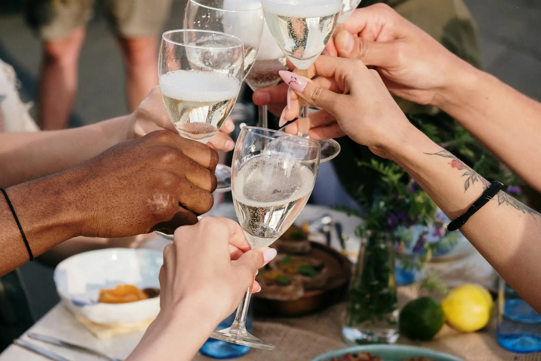 Twee mensen klinken met wijnglazen aan tafel